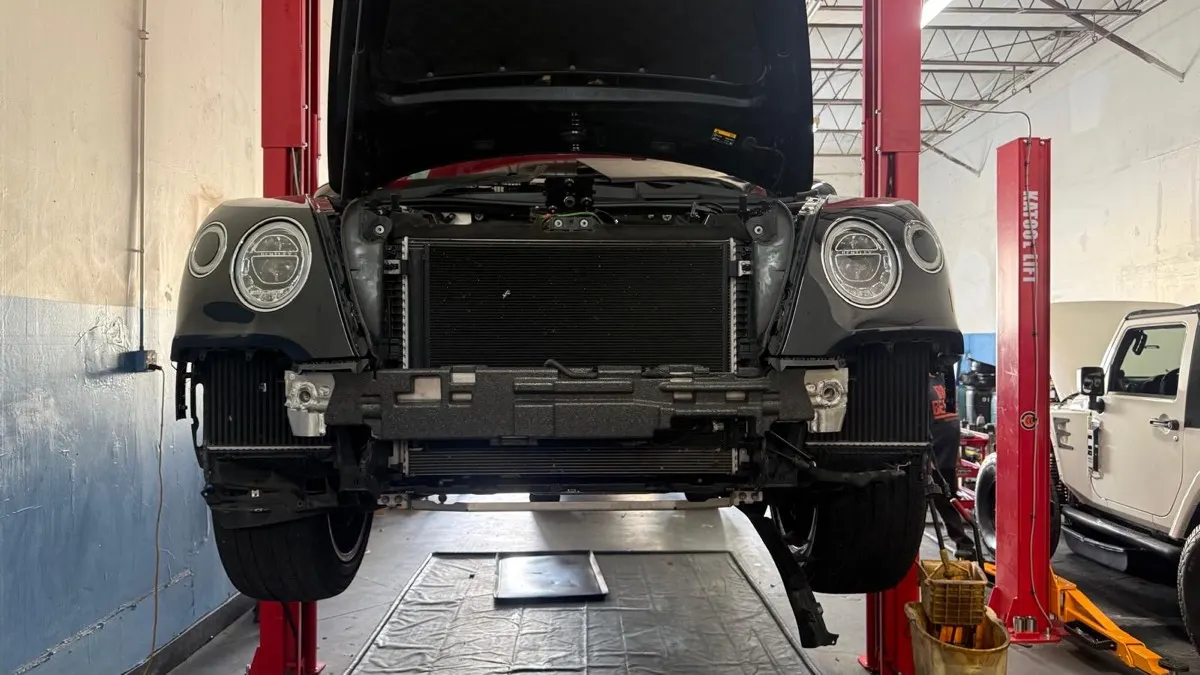 Service bay with a Bentley on the lift and a Jeep alongside