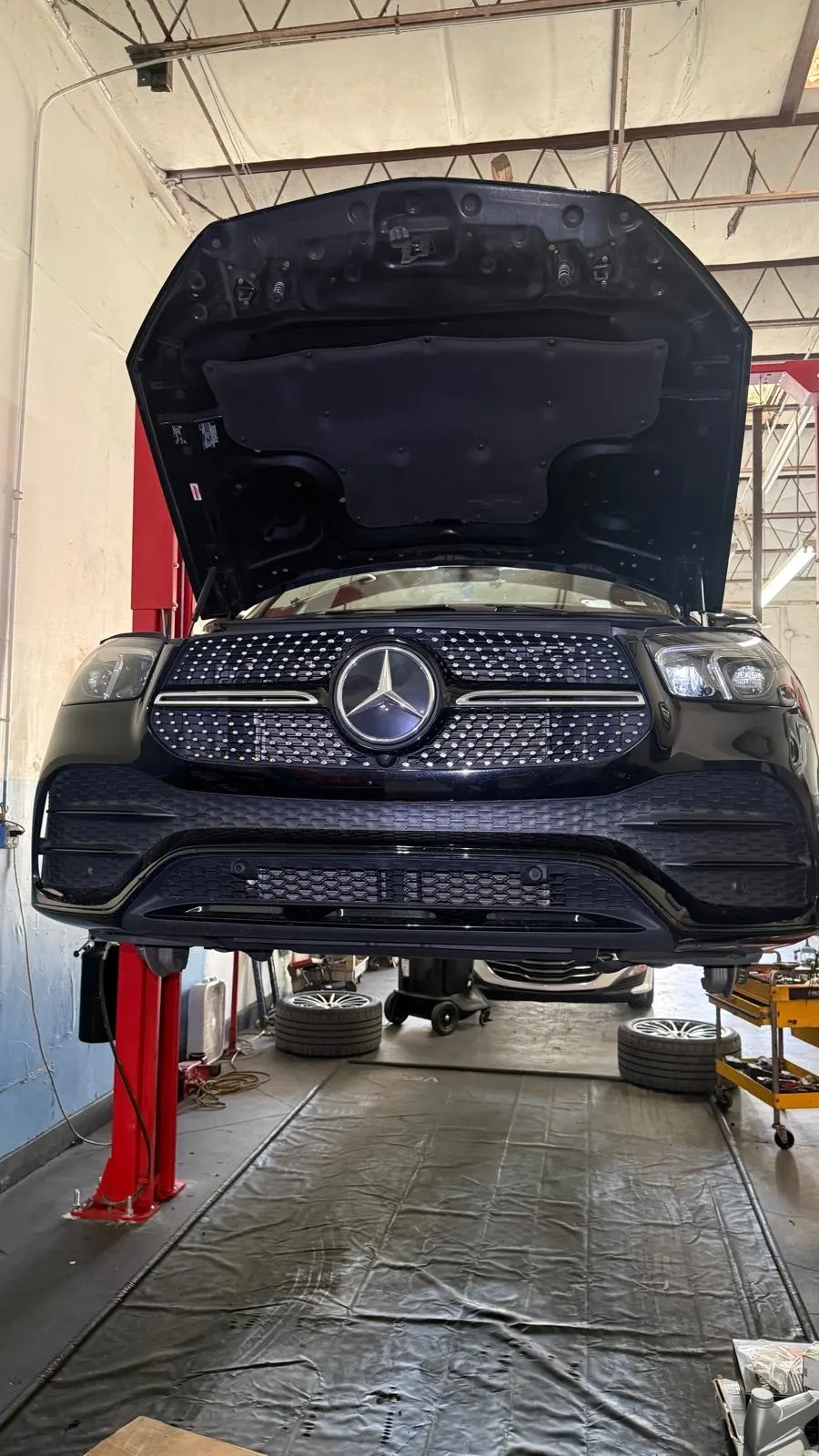 Mercedes GLE on the lift with the hood open at Phil's Electric Auto Expert in Pompano Beach